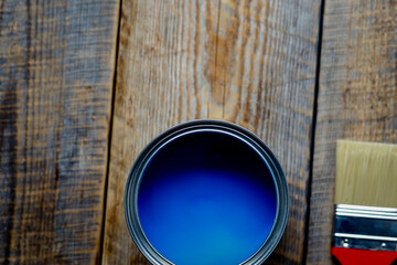 painting  with can blue paint on wooden background top view