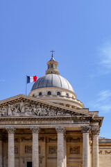 Fototapeta premium Classic architecture of the Pantheon with detailed sculptures and French flag flying above the dome