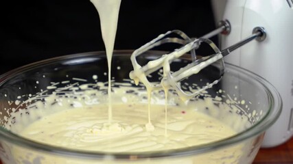 Pouring creamy dessert batter into a glass bowl to mix with electric beater, perfect for cooking shows or baking tutorials, sweet indulgence