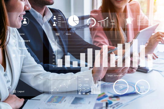 A diverse business team engaging in a collaborative meeting, analyzing data through digital visuals and discussing performance metrics for informed decision-making. Impute - Powered by Adobe