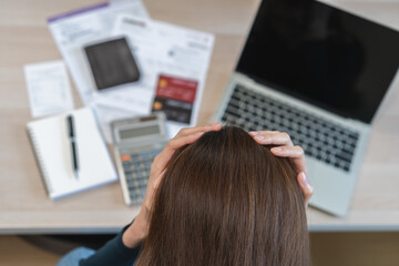 Financial owe asian woman sitting stressed by calculate expense at home, looking at invoice or...
