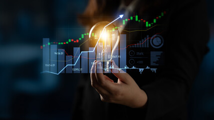 Business professional holds a light bulb symbolizing innovative ideas against a background of financial graphs, showcasing growth and strategic market analysis. Scalp