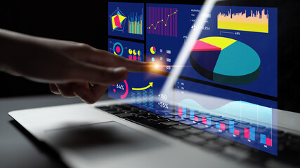 A hand interacts with charts and graphs on a laptop screen, showcasing modern business analytics and data visualization in a sleek, dark environment. Impute