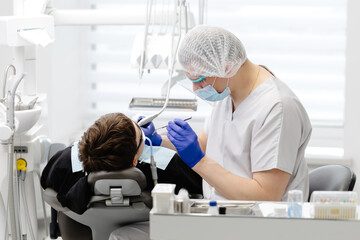 Dentist performing dental checkup on young patient