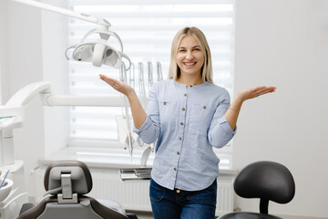 Surprised patient showing something with hands in dental clinic