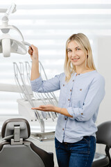 Dentist adjusting dental light in clinic