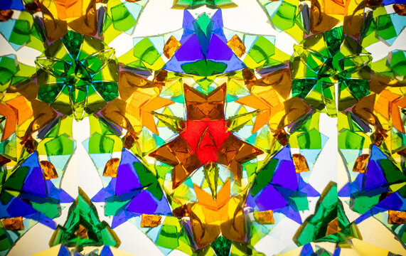 Natural kaleidoscope pattern captured with a camera, featuring vibrant stained glass colors and geometric symmetry.