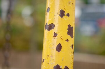 黄色の塗装が剥がれ錆びかけたブランコの支柱