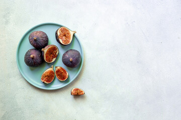Fresh ripe figs on a plate top view on a gray background