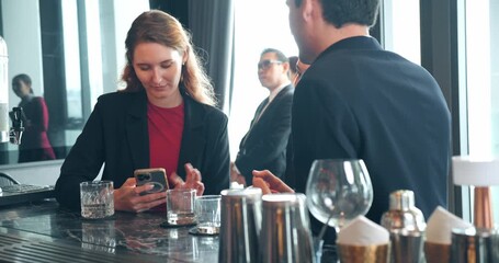 Business colleagues talking and typing their phones to instantly share digital contact information during a formal networking event - Powered by Adobe