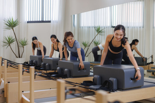 Women exercising pilates on reformers in studio