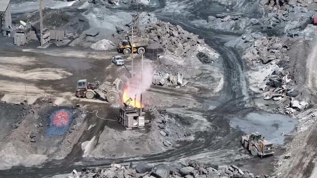 Loader dumps glowing liquid slag at an industrial processing site