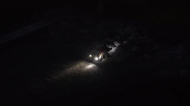 Night dump truck deposits fiery molten material into slag pit