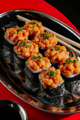 Gunkan rolls with chopsticks on a metal plate
