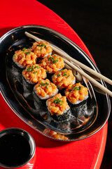 Gunkan rolls with chopsticks on a metal plate