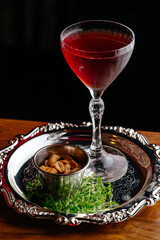a glass of wine in a restaurant on a tray with nuts