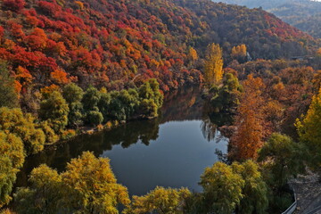 Soldier Lake. An urban lake surrounded by mountains with different vegetation. Autumn time, view from the drone.