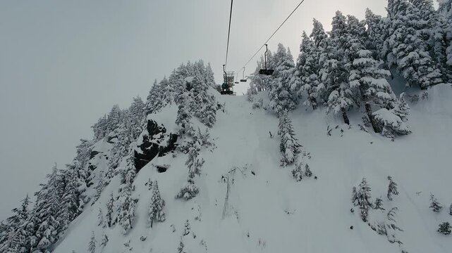 Riding Steep Chairlift Over Difficult Winter Terrain
