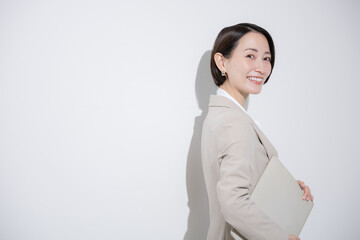 A woman with a laptop, camera-ready smile, smiling salesperson or career woman