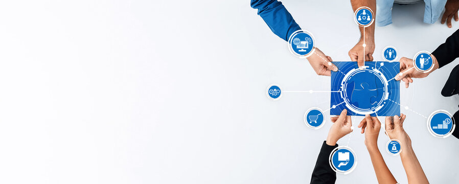 A diverse group of hands collaborates around a digital device displaying icons for strategy, finance, and data, symbolizing teamwork and innovative business solutions. Amity - Powered by Adobe