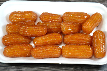Balah el Sham or Egyptian Choux Pastry, very popular Ramadan month dessert in Egypt and middle east, crispy and tender choux pastry deeply fried and coated in sweet simple sugar syrup, served cold