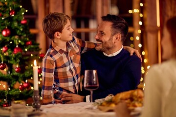 Warm Christmas Dinner Moment Between Father And Son By Tree At Home