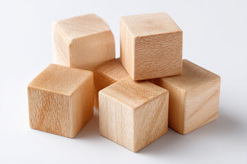 Wooden blocks piled against a white background symbolize childhood creativity and simplicity, offering a blank canvas for imagination.