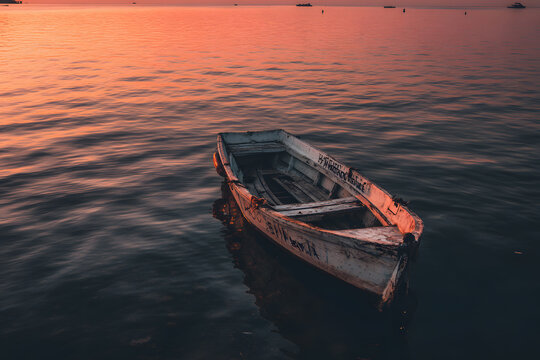 a boat is sitting in the water at sunset