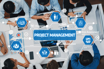 Team members engage in collaborative project management discussions, utilizing digital data and charts to enhance decision-making and productivity in a modern workspace. Amity