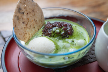 Traditional Japanese matcha dessert with red bean paste and mochi in glass bowl