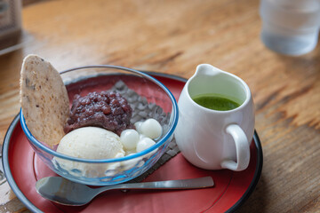 Japanese dessert with ice cream red bean paste mochi and green tea sauce on wooden table