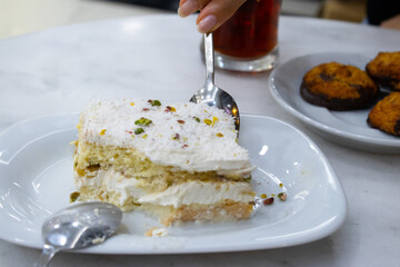 Rich Slice of Cream and Sponge Layer Cake with Coconut and Pistachio
