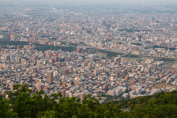 Panoramic view from Moiwa mountain, Aerial view of dense urban cityscape with buildings and greenery at Sapporo, Hokkaido, Japan