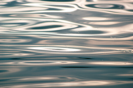 Abstract macro view of the rippling water surface reflecting bright sunlight - Powered by Adobe