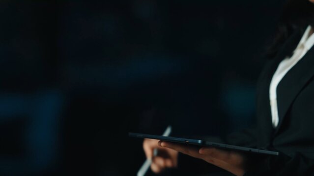 Professional Woman Holding Digital Tablet with Stylus in Dark Environment for Business and Technology Themes. Asymptotic smart data analytic.
