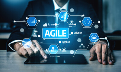 A businessman in a formal suit interacts with a tablet displaying icons representing agile methodologies, promoting teamwork and effective project management in a digital age. Tessel