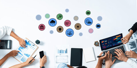 A top-down view of a business meeting featuring collaborative teamwork with digital analysis tools, charts, and icons on a clean workspace, promoting productivity and innovation. Trope