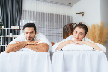 Obraz premium Caucasian couple customer enjoying relaxing anti-stress spa massage and pampering with beauty skin recreation leisure in day light ambient salon spa at luxury resort or hotel. Quiescent