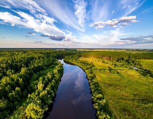 Obraz premium Aerial view of a winding river amidst lush green forest and fields