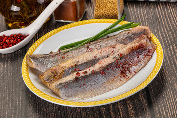 Salted marinated herring fillet with spices