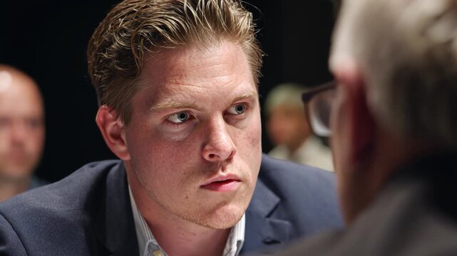 Focused Discussion: A man engaged in an intense conversation, his gaze locked on the person opposite him. This image conveys the importance of dialogue and careful consideration.