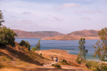 Vibrant view of a large lake near Marrakech with small figures of people gathered along its sandy edge, reflecting community and leisure in Moroccan nature.
