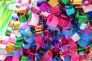 七夕飾りの一部であるメタリックな光沢を持つピンクや青や緑などのカラフルな紙テープや輪が密集して吊り下げられている