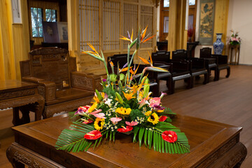 Traditional Chinese room, living room with flower arrangement and solid wood tables and chairs