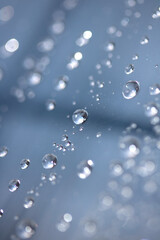 Close up of abstract floating bubbles water droplets condensation rain on a glass transparent bokeh background