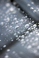 Close up of abstract floating bubbles water droplets condensation rain on a glass transparent bokeh background