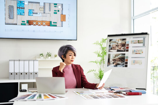 Architectural woman working on blueprint in office.Business of Real estate, home decoration and renovation concept.Interior designer in office working on a project. - Powered by Adobe