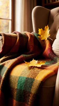 Cozy Armchair With Plaid Blanket And Autumn Leaves By Window With Soft Sunlight