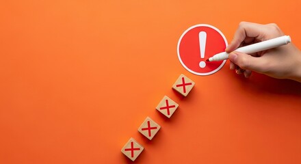 Hand marking an exclamation point on a red circle near x marked wooden blocks
