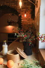 Festive Kitchen Decorations: Berry Branches, Milk, Orange and Wicker Basket in Warm Lights